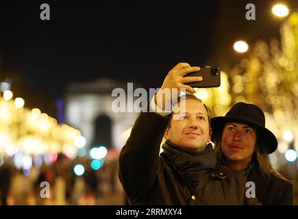 221121 -- PARIGI, 21 novembre 2022 -- le persone scattano foto agli Champs-Elysees illuminati dalle luci natalizie a Parigi, in Francia, 20 novembre 2022. La cerimonia annuale di illuminazione natalizia si è tenuta qui domenica. Le luci sulla famosa avenue verranno spente alle 23:45 anziché alle 2:00 del mattino e dureranno fino al 2 gennaio 2023, una settimana prima del solito per risparmiare energia. FRANCIA-PARIGI-NATALE ILLUMINAZIONE-RISPARMIO ENERGETICO GAOXJING PUBLICATIONXNOTXINXCHN Foto Stock