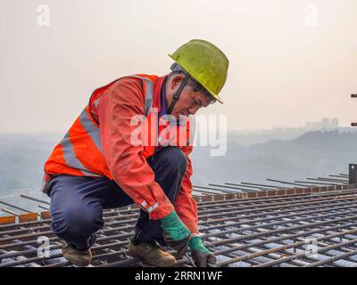 221129 -- CHONGQING, 29 novembre 2022 -- Un lavoratore è in servizio presso il cantiere del mega ponte Huafu nella sezione Sichuan-Chongqing della ferrovia ad alta velocità Chongqing-Kunming nel comune di Chongqing, 28 novembre 2022. La ferrovia ad alta velocità Chongqing-Kunming, lunga 699 chilometri, con una velocità progettata di 350 chilometri all'ora, è un componente chiave del corridoio ferroviario che collega la capitale cinese Pechino e Kunming nella provincia dello Yunnan della Cina sud-occidentale. CHINA-CHONGQING-COSTRUZIONE FERROVIARIA AD ALTA VELOCITÀ CN ZHUXGAOXIANG PUBLICATIONXNOTXINXCHN Foto Stock