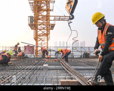 221129 -- CHONGQING, 29 novembre 2022 -- i lavoratori sono in servizio presso il cantiere del mega ponte Huafu nella sezione Sichuan-Chongqing della ferrovia ad alta velocità Chongqing-Kunming nel comune di Chongqing nella Cina sud-occidentale, 28 novembre 2022. La ferrovia ad alta velocità Chongqing-Kunming, lunga 699 chilometri, con una velocità progettata di 350 chilometri all'ora, è un componente chiave del corridoio ferroviario che collega la capitale cinese Pechino e Kunming nella provincia dello Yunnan della Cina sud-occidentale. CHINA-CHONGQING-COSTRUZIONE FERROVIARIA AD ALTA VELOCITÀ CN WANGXQUANCHAO PUBLICATIONXNOTXINXCHN Foto Stock