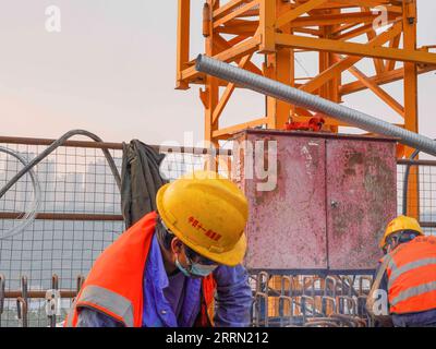 221129 -- CHONGQING, 29 novembre 2022 -- i lavoratori sono in servizio presso il cantiere del mega ponte Huafu nella sezione Sichuan-Chongqing della ferrovia ad alta velocità Chongqing-Kunming nel comune di Chongqing nella Cina sud-occidentale, 28 novembre 2022. La ferrovia ad alta velocità Chongqing-Kunming, lunga 699 chilometri, con una velocità progettata di 350 chilometri all'ora, è un componente chiave del corridoio ferroviario che collega la capitale cinese Pechino e Kunming nella provincia dello Yunnan della Cina sud-occidentale. CHINA-CHONGQING-COSTRUZIONE FERROVIARIA AD ALTA VELOCITÀ CN ZHUXGAOXIANG PUBLICATIONXNOTXINXCHN Foto Stock