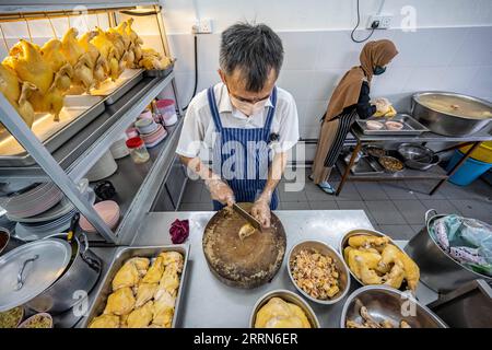 221215 -- KOTA KINABALU, 15 dicembre 2022 -- Andrew Wong Hin Hau prepara il pollo per il riso di pollo Hainan a Kota Kinabalu a Sabah, Malesia, 3 dicembre 2022. DA ABBINARE: Riso di pollo hainanese tutta la rabbia in Sud Asia MALESIA-KOTA KINABALU-HAINANESE RISO DI POLLO ZhuxWei PUBLICATIONxNOTxINxCHN Foto Stock