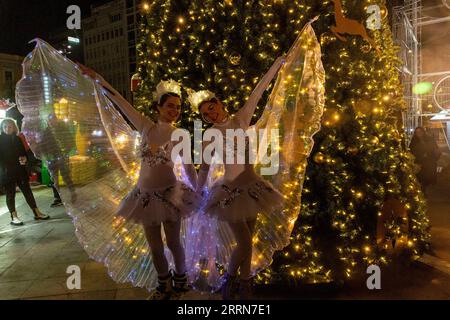 221219 -- GRECIA, 19 dicembre 2022 -- due ragazze vestite come fate si pongono da un albero di Natale ad Atene, in Grecia, il 18 dicembre 2022. GRECIA-ATENE-MERCATINO DI NATALE MariosxLolos PUBLICATIONxNOTxINxCHN Foto Stock