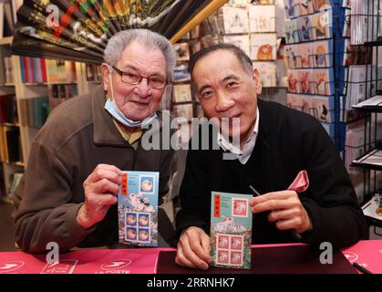 230115 -- PARIGI, 15 gennaio 2023 -- Un cliente posa per una foto con l'artista cinese Chen Jianghong R, designer dell'anno dei francobolli commemorativi del coniglio, durante una cerimonia di lancio a Parigi, in Francia, 14 gennaio 2023. L'ufficio postale francese, la Poste, il sabato ha emesso due francobolli per celebrare il prossimo Capodanno cinese, l'anno del Coniglio, che inizia il 22 gennaio. FRANCE-PARIS-STAMP-ANNO DEL CONIGLIO GAOXJING PUBLICATIONXNOTXINXCHN Foto Stock