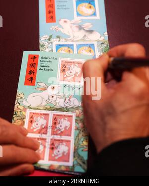 230115 -- PARIGI, 15 gennaio 2023 -- l'artista cinese Chen Jianghong firma i francobolli commemorativi dell'anno del Coniglio progettati da lui durante una cerimonia di lancio a Parigi, in Francia, 14 gennaio 2023. L'ufficio postale francese, la Poste, il sabato ha emesso due francobolli per celebrare il prossimo Capodanno cinese, l'anno del Coniglio, che inizia il 22 gennaio. FRANCE-PARIS-STAMP-ANNO DEL CONIGLIO GAOXJING PUBLICATIONXNOTXINXCHN Foto Stock