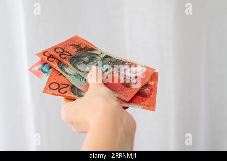 Donna in possesso di valuta australiana - venti dollari di banconote australiane Foto Stock