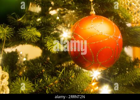 Primo piano di un bauble rosso appeso su un albero di Natale Foto Stock