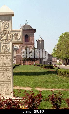 Bucarest, Romania, circa 2000. Vista della cattedrale patriarcale ortodossa rumena e del campanile sul colle Mitropoliei (Dealul Mitropoliei). In primo piano, una croce di pietra del 1713 con iscrizioni in slavo, per Papa Brâncoveanu, padre di Constantin Brâncoveanu, Principe di Valacchia. Foto Stock