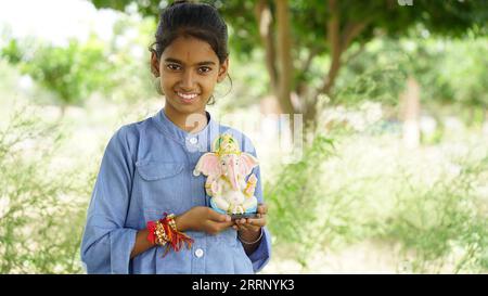 Bambina indiana con il signore ganesha e la preghiera, festa indiana dei ganesh o festival di Diwali Foto Stock