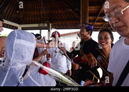 230216 -- BALI, 16 febbraio 2023 -- personale turistico locale presenta fiori ai turisti cinesi sull'isola di Nusa Lembongan, Bali, Indonesia, il 14 febbraio 2023. Circa 1.000 turisti provenienti dalla Cina continentale hanno visitato Bali dal 22 gennaio 2023, quando questa famosa isola turistica ha accolto quest'anno il primo gruppo di turisti cinesi con un volo charter da Shenzhen, in Cina. INDONESIA-BALI-TURISTI CINESI RITORNANO XuxQin PUBLICATIONxNOTxINxCHN Foto Stock