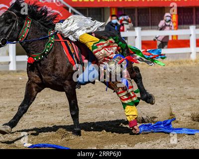 230224 -- LHASA, 24 febbraio 2023 -- Un cavaliere prende l'hada durante uno spettacolo equestre a Lhasa, nella regione Autonoma Tibet del sud-ovest della Cina, 23 febbraio 2023. Giovedì si è tenuto uno spettacolo equestre annuale per celebrare il Capodanno tibetano. CHINA-TIBET-LHASA-TIBETAN NEW YEAR-EQUESTRIAN SHOW CN ZHANGXRUFENG PUBLICATIONXNOTXINXCHN Foto Stock