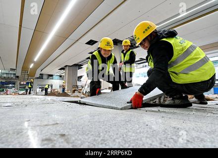 230224 -- FUZHOU, 24 febbraio 2023 -- i costruttori posano piastrelle di pavimento alla stazione ferroviaria di Fuzhou Sud a Fuzhou, provincia del Fujian della Cina sud-orientale, 21 febbraio 2023. La ferrovia di 277 km corre lungo la costa sud-orientale della Cina e attraversa tre baie principali su giganteschi ponti. È la prima ferrovia ad alta velocità del paese. Con una velocità progettata di 350 km all'ora e otto stazioni lungo il percorso, si prevede che il tempo di percorrenza tra le due città diminuirà a un'ora. CHINA-FUZHOU-XIAMEN-FERROVIA AD ALTA VELOCITÀ CN LINXSHANCHUAN PUBLICATIONXNOTXINXCHN Foto Stock