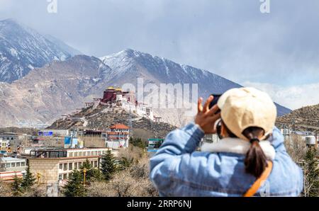 230224 -- LHASA, 24 febbraio 2023 -- Un turista scatta foto al Palazzo del Potala dopo una nevicata a Lhasa, nella regione Autonoma Tibet della Cina sud-occidentale, 24 febbraio 2023. Foto di /Xinhua CHINA-TIBET-LHASA-SNOW CN TenzinxNyida PUBLICATIONxNOTxINxCHN Foto Stock