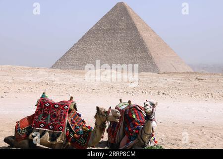 230302 -- CAIRO, 2 marzo 2023 -- cammelli sono visti vicino alla Piramide di Khufu a Giza, Egitto, il 2 marzo 2023. Una scoperta di un corridoio lungo nove metri e largo 2,10 metri dietro la grande Piramide di Giza, nota come Piramide di Khufu, è stata annunciata giovedì. Il ministro egiziano del turismo e delle antichità Ahmed Issa ha affermato che la scoperta è il risultato del progetto internazionale ScanPyramids lanciato nel 2015 dal Ministero delle antichità egiziano per studiare la struttura delle piramidi senza utilizzare metodi di perforazione dannosi. EGYPT-GIZA-KHUFU PYRAMID-NEW CORRIDOR-DISCOVERY AHMEDXGOMAA PUBLICATION Foto Stock