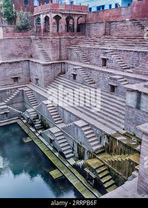 Una parete del pozzo Jodhpur (Toorji Ka Jhalra Bavdi) mostra un piccolo ristorante nell'angolo. Foto Stock