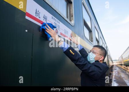 230311 -- HANGZHOU, 11 marzo 2023 -- Un operaio ferroviario pulisce l'etichetta delle indicazioni sul treno n.. Y71 a Hangzhou, provincia di Zhejiang, Cina orientale, 10 marzo 2023. La notte del 10 marzo, il treno n.. Y71, un treno noleggiato per il turismo ferroviario transprovinciale, partì dalla stazione ferroviaria di Hangzhou, trasportando oltre 420 passeggeri verso l'altopiano dello Yunnan-Guizhou. Con l'arrivo della primavera, China Railway Shanghai Bureau Group Co., Ltd. Ha attivamente formulato piani turistici ferroviari di alta qualità e ha iniziato la gestione di treni a noleggio destinati a destinazioni popolari, al fine di soddisfare la crescente t Foto Stock