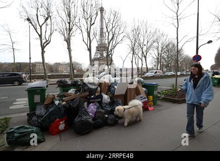 230316 -- PARIGI, 16 marzo 2023 -- Una donna cammina davanti alla spazzatura lasciata sulla strada vicino alla Torre Eiffel a Parigi, in Francia, 15 marzo 2023. È probabile che la spazzatura continui ad accumularsi nella capitale, poiché i raccoglitori di rifiuti e le pulizie stradali saranno in sciopero fino al 20 marzo. Secondo il municipio, circa 76.000 tonnellate di rifiuti devono essere raccolte entro mercoledì a Parigi. FRANCE-PARIS-GARBAGE ON STREET GaoxJing PUBLICATIONxNOTxINxCHN Foto Stock