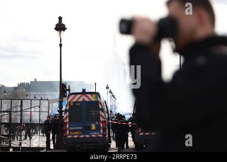 230316 -- PARIGI, 16 marzo 2023 -- poliziotti e gendarmi stanno di guardia durante la manifestazione contro il piano di riforma pensionistica del governo a Parigi, in Francia, 15 marzo 2023. Mentre centinaia di migliaia di francesi protestarono in tutta la Francia per le controverse riforme pensionistiche, mercoledì la commissione mista del Parlamento francese ha discusso il progetto di legge. Mercoledì sera il ministero degli interni francese ha annunciato che 480.000 persone in tutto il paese avevano partecipato all'ottava mobilitazione generale contro le riforme, organizzate dai sindacati. FRANCIA-PARIGI-RIFORMA DELLE PENSIONI PLA Foto Stock