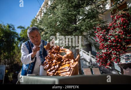 230317 -- JIANCHUAN, 17 marzo 2023 -- Duan Sixing lavora con la scultura in legno nella contea di Jianchuan, prefettura autonoma di Dali Bai nel sud-ovest della Cina, provincia dello Yunnan, 2 dicembre 2022. La contea di Jianchuan, situata nella prefettura autonoma di Dali Bai nella provincia dello Yunnan della Cina sud-occidentale, ha una lunga storia nell'intaglio del legno che risale alle dinastie Tang 618-907 e Song 960-1279. Le abilità di intaglio si sono gradualmente sviluppate da un rilievo a uno strato fino a un rilievo scavato a sette strati, e sono ora applicate alla realizzazione di parti architettoniche, mobili in legno, dipinti murali e souvenir turistici. Una F. Di alto livello Foto Stock