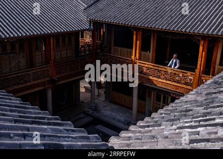 230317 -- JIANCHUAN, 17 marzo 2023 -- Duan Sixing controlla nel cantiere del suo museo di sculture in legno nella contea di Jianchuan, prefettura autonoma di Dali Bai nel sud-ovest della Cina, provincia dello Yunnan, 11 marzo 2023. La contea di Jianchuan, situata nella prefettura autonoma di Dali Bai nella provincia dello Yunnan della Cina sud-occidentale, ha una lunga storia nell'intaglio del legno che risale alle dinastie Tang 618-907 e Song 960-1279. Le abilità di intaglio si sono gradualmente sviluppate da un rilievo a un solo strato fino a un rilievo scavato a sette strati, e sono ora applicate alla realizzazione di parti architettoniche, mobili in legno, pitture murali e touris Foto Stock