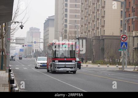 230321 -- XIONG AN, 21 marzo 2023 -- un autobus intelligente collegato è visto in un'operazione di prova in una strada nell'area di Rongdong di Xiong An New area, nella provincia di Hebei nella Cina settentrionale, 20 marzo 2023. Questo autobus passeggeri a guida autonoma è dotato di sensori ad alta precisione, tra cui radar laser, radar ad onde millimetriche e telecamere HD, e in grado di prendere decisioni operative in un decimo di secondi. Può anche far fronte a condizioni meteorologiche avverse e complicare le situazioni di traffico. EYESONSCICHINA-HEBEI-XIONG AN-AUTO-DRIVE BUS-TRIAL OPERATION CN DUXYIFANG PUBLICATIONXNOTXINXCHN Foto Stock