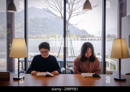 230321 -- HANGZHOU, 21 marzo 2023 -- la gente legge libri in una libreria accanto a un fiume a Leqing, nella provincia di Zhejiang nella Cina orientale, 17 marzo 2023. La provincia di Zhejiang ha considerato la gestione dell'ambiente idrico come priorità assoluta nella costruzione ecologica, elevando la qualità dell'acqua di centinaia di laghi e fiumi e stabilendo siti di attività civica sul lungomare. CHINA-ZHEJIANG-WATER-ENVIRONMENT-MANAGEMENT CN JIANGXHAN PUBLICATIONXNOTXINXCHN Foto Stock