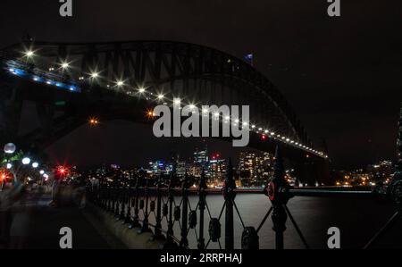 230325 -- SYDNEY, 25 marzo 2023 -- il Sydney Harbor Bridge si oscura durante l'evento Earth Hour a Sydney, Australia, 25 marzo 2023. I luoghi di interesse dell'Australia, tra cui la Sydney Opera House e il Sydney Harbor Bridge, si sono oscurati per un'ora il sabato sera come parte di un movimento globale per sensibilizzare sui cambiamenti climatici e la perdita della natura. Earth Hour 2023 mira a sensibilizzare l'opinione pubblica sull'importanza degli alberi e della natura per la fauna selvatica, le comunità e il benessere fisico e mentale delle persone. Foto di /Xinhua AUSTRALIA-SYDNEY-EARTH HOUR HuxJingchen PUBLICATIONxNOTxINxCHN Foto Stock