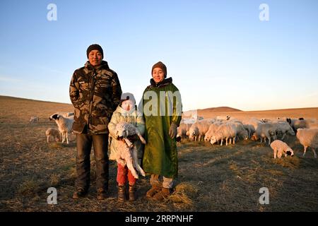 230403 -- XILINGOL LEAGUE, 3 aprile 2023 -- Herdsman Tsogdelger L posa per una foto di gruppo con la moglie Munguntuya R e la figlia Halgian nel pascolo di Ujimqin Occidentale Banner della Xilingol League, regione autonoma della Mongolia interna della Cina settentrionale, 29 marzo 2023. In primavera, la stagione più movimentata dell'anno, Tsogdelger, un allevatore del gruppo etnico mongolo, e la sua famiglia hanno bisogno di assistere con agnello e nutrire il bestiame ogni giorno. Più di 280 agnelli sono nati nella sua fattoria dal 18 marzo. Dall'inizio di quest'anno fino al marzo 30, un totale di 581.300 figli sono nati a West Ujimqin Bann Foto Stock