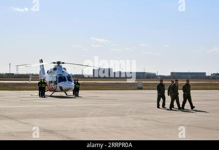 230407 -- TIANJIN, 7 aprile 2023 -- i membri dell'equipaggio escono da un elicottero civile bimotore AC332 dopo il suo primo volo a pieno regime presso l'Aviation Industry Corporation of China AVIC Tianjin Helicopter Co., Ltd nel nord della Cina a Tianjin, 7 aprile 2023. L'elicottero civile bimotore AC332 della Cina ha condotto con successo il suo primo volo a pieno regime qui venerdì, ha annunciato il suo sviluppatore, l'AVIC. L'elicottero multiuso da 4 tonnellate ha ricevuto il suo primo lotto di 24 ordini dai suoi operatori di lancio lo stesso giorno, ha detto l'AVIC, il principale costruttore di pialleria del paese. L'elicottero ha il massimo Foto Stock