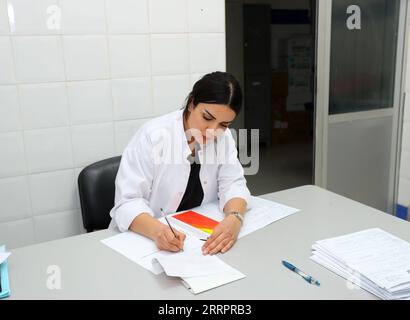 230408 -- BEN GUERIR, 8 aprile 2023 -- il medico marocchino Rachidi Imane lavora presso il Rhamna Provincial Central Hospital di Ben Guerir, Marocco, 26 febbraio 2023. Sono un esempio vivente tra le migliaia di casi salvati dai medici cinesi in Marocco, Rachidi Imane, un medico marocchino, ha ricordato come è stata salvata al momento della nascita da un medico cinese 42 anni fa. PER ANDARE CON la caratteristica: Quando diventerò te -- il medico marocchino condivide il suo legame personale con la Cina MAROCCO-BEN GUERIR-SQUADRA MEDICA CINESE-MEDICO MAROCCHINO SuixXiankai PUBLICATIONxNOTxINxCHN Foto Stock