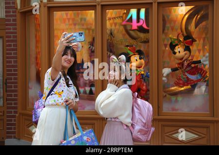 230411 -- TOKYO, 11 aprile 2023 -- i visitatori si mettono in posa per una foto a Tokyo Disneyland nella prefettura di Chiba, Giappone, 10 aprile 2023. Tokyo Disneyland presenterà una nuova parata diurna chiamata Disney Harmony in Color sabato per svelare le festività di un anno che commemorano il suo 40° anniversario. La sfilata di 45 minuti, che include personaggi di film Disney come Zootopia Moana e Wreck-it Ralph, oltre ai favoriti di lunga data, è stata mostrata alla stampa lunedì. GIAPPONE-TOKYO-DISNEYLAND-40° ANNIVERSARIO QianxZheng PUBLICATIONxNOTxINxCHN Foto Stock