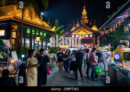 230412 -- MANGSHI, 12 aprile 2023 -- i turisti visitano un'antica città dai nella città di Mangshi, nella prefettura autonoma di Dehong dai e Jingpo, nella provincia dello Yunnan della Cina sud-occidentale, 11 aprile 2023. L'antica città presenta elementi culturali locali per migliorare l'esperienza del tour notturno dei turisti e potenziare il turismo culturale locale. CHINA-YUNNAN-MANGSHI-NIGHT-TOURISM CN CHENXXINBO PUBLICATIONXNOTXINXCHN Foto Stock