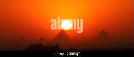 230416 -- CAIRO, 16 aprile 2023 -- questa foto scattata il 15 aprile 2023 mostra le piramidi di Giza al tramonto viste dal Cairo, in Egitto. EGITTO-CAIRO-PIRAMIDI DI GIZA-TRAMONTO SuixXiankai PUBLICATIONxNOTxINxCHN Foto Stock