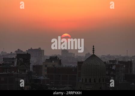 230416 -- CAIRO, 16 aprile 2023 -- questa foto scattata il 15 aprile 2023 mostra le piramidi di Giza al tramonto viste dal Cairo, in Egitto. EGITTO-CAIRO-PIRAMIDI DI GIZA-TRAMONTO AhmedxGomaa PUBLICATIONxNOTxINxCHN Foto Stock