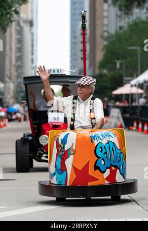 230416 -- HOUSTON, 16 aprile 2023 -- Un autista di un'auto d'arte ondata nella 36a Houston Art Car Parade a Houston, Texas, Stati Uniti, 15 aprile 2023. L'evento annuale ha riunito oltre 250 auto d'arte e altre mostre, attirando più di 250.000 spettatori. La sfilata ha presentato una vasta gamma di veicoli a ruote, tra cui biciclette, unicicli, rasaerba, automobili, e go-kart. Foto di /Xinhua U.S.-HOUSTON-ART CAR PARADE ChenxChen PUBLICATIONxNOTxINxCHN Foto Stock