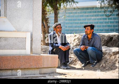 230430 -- YECHENG, 30 aprile 2023 -- questa foto scattata il 29 aprile 2011 mostra Eniwar Emer R e suo padre Emer YIT mentre chiacchierano nel cimitero dei martiri di Yecheng, nella regione autonoma di Xinjiang Uygur, nella Cina nord-occidentale. Ogni aprile, i fiori fioriscono nel cimitero dei martiri di Yecheng, nella regione autonoma Xinjiang Uygur dello Xinjiang, nella Cina nord-occidentale, dove sono stati sepolti 233 martiri. Mi prenderò cura del cimitero, ha detto Eniwar Emer, 53 anni, davanti alla lapide di suo padre. Eniwar è un custode di seconda generazione del cimitero dei martiri di Yecheng, seguendo le orme di suo padre Emer YIT Foto Stock