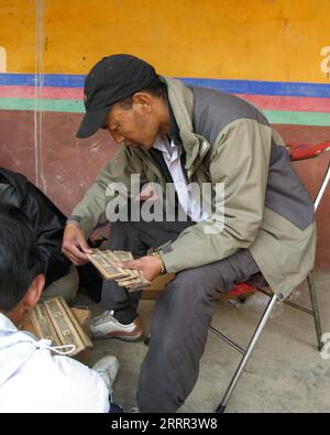 230430 -- LHASA, 30 aprile 2023 -- questa foto del file scattata il 27 luglio 2008 mostra Gyumey Tsultrim che osserva i manoscritti di foglie di palma dei sutra buddisti nella regione autonoma del Tibet nel sud-ovest della Cina. Al Palazzo Truzing di Norbulingka, nei sobborghi occidentali di Lhasa, migliaia di libri antichi su vari campi del Tibet sono conservati sugli scaffali. Per ora, Gyumey Tsultrim e i suoi colleghi il compito principale è quello di fare un inventario degli antichi libri sia manualmente che digitalmente. Gyumey Tsultrim nacque nel 1967 nella contea di Chanang nello Shannan. Nel 1986, mentre esperti dell'Accademia delle Scienze sociali del Tibe Foto Stock