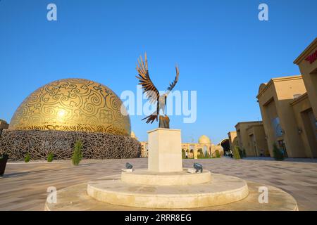 Vista della cupola d'oro, del nido d'uccello del Samruk Flying Theater nella zona del tour. Con statua di falco. In Turkestan, Kazakistan. Foto Stock