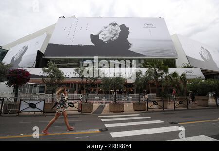 230516 -- CANNES, 16 maggio 2023 -- Una donna cammina davanti a un enorme poster della 76a edizione del Festival di Cannes fuori dal Palais du Festival di Cannes, nel sud della Francia, 15 maggio 2023. Il festival cinematografico si terrà dal 16 al 27 maggio 2023. FRANCIA-CANNES-FILM FESTIVAL-PREPARAZIONE GaoxJing PUBLICATIONxNOTxINxCHN Foto Stock