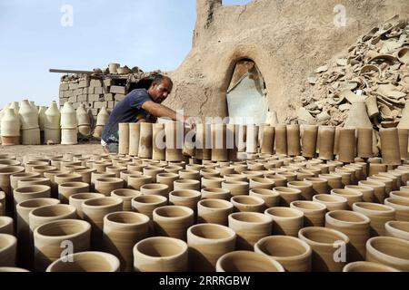 230528 -- BAGHDAD, 28 maggio 2023 -- Safaa al-Kawaz, proprietario di un laboratorio di ceramica, organizza oggetti di terracotta nella zona di Nahrawan vicino a Baghdad, Iraq, 27 maggio 2023. La fabbricazione della ceramica in Iraq è stata una professione duratura, profondamente radicata nelle civiltà della Mesopotamia. IRAQ-BAGHDAD-FABBRICAZIONE DI CERAMICA KhalilxDawood PUBLICATIONxNOTxINxCHN Foto Stock