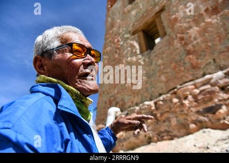 230528 -- ZANDA, 28 maggio 2023 -- Rigzin Wangzhab ispeziona una grotta nella contea di Zanda della prefettura di Ngari, regione autonoma Tibet della Cina sud-occidentale, 26 maggio 2023. Nascosto tra le colline di arenaria nel remoto Tibet occidentale, un tratto di caverne a forma di nido d'ape è ben oltre la portata della maggior parte dei viaggiatori. Conosciute come le grotte di Donggar e Piyang, le caverne di 1.000 anni nella prefettura di Ngari della regione autonoma del Tibet ospitano una delle più grandi collezioni al mondo di murales buddisti tibetani. Rigzin Wangzhab, 75 anni, è stato a guardia del sito per più di 20 anni. Quando ero molto giovane, mi è stato detto che Foto Stock