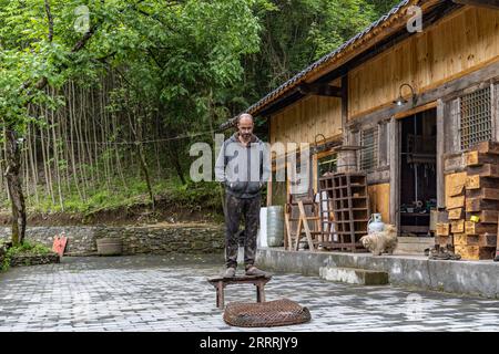 230531 -- CHONGQING, 31 maggio 2023 -- Vincent Cazeneuve è raffigurato fuori dal suo studio nel villaggio di Songbai di Beiping Town, contea di Chengkou, municipalità di Chongqing della Cina sud-occidentale, 29 maggio 2023. Lo studio Vincent Cazeneuve, una casa in legno a due piani circondata da alberi di lacca, si trova nel profondo dei Monti Daba nella città Beiping della contea di Chengkou, nella municipalità di Chongqing della Cina sud-occidentale. Affascinato dall'arte della lacca, l'artista francese è venuto in Cina 15 anni fa con l'obiettivo di trovare la specie di albero della lacca adatta per realizzare opere d'arte della lacca. Aveva visitato molti posti in Cina, e infine Foto Stock