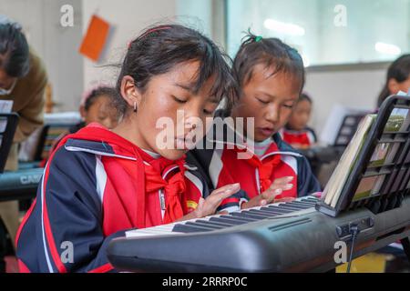 230608 -- TINGRI, 8 giugno 2023 -- gli alunni frequentano una lezione di pianoforte presso una scuola elementare della Zhaxizom Township nella contea di Tingri, città di Xigaze, regione autonoma Tibet del sud-ovest della Cina, 5 giugno 2023. La scuola elementare di Zhaxizom Township è la scuola più vicina al Monte Qomolangma, con una distanza di poco più di 40 chilometri. Per soddisfare le diverse esigenze degli studenti, la scuola ha istituito corsi di interesse come pianoforte, informatica, arte, radiodiffusione, sport, danza e artigianato. Attualmente, la scuola elementare ha un solo pianoforte. Pertanto, le tastiere elettroniche vengono utilizzate come sostituti Foto Stock