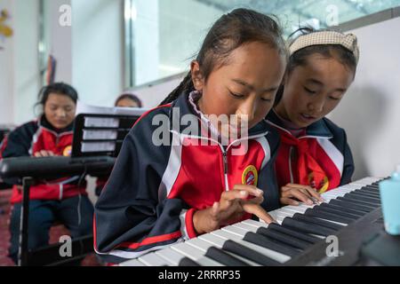 230608 -- TINGRI, 8 giugno 2023 -- gli alunni frequentano una lezione di pianoforte presso una scuola elementare della Zhaxizom Township nella contea di Tingri, città di Xigaze, regione autonoma Tibet del sud-ovest della Cina, 5 giugno 2023. La scuola elementare di Zhaxizom Township è la scuola più vicina al Monte Qomolangma, con una distanza di poco più di 40 chilometri. Per soddisfare le diverse esigenze degli studenti, la scuola ha istituito corsi di interesse come pianoforte, informatica, arte, radiodiffusione, sport, danza e artigianato. Attualmente, la scuola elementare ha un solo pianoforte. Pertanto, le tastiere elettroniche vengono utilizzate come sostituti Foto Stock