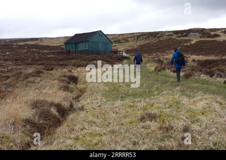 Due uomini che camminano lungo il sentiero fino a "The Lunch House", Sleddale Pike, Shap Hills, Wet Sleddale, Lake District National Park, Cumbria, Inghilterra, Regno Unito. Foto Stock