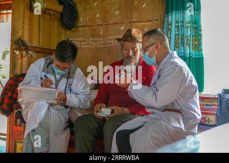 230615 -- LHASA, 15 giugno 2023 -- Wang Zhenjiang 1st R mostra l'istruzione della medicina a Dawa Sambu C durante il suo trattamento in un villaggio nella città di Mainling, nella regione autonoma del Tibet della Cina sud-occidentale, 12 giugno 2023. Wang Zhenjiang, Chen Bing e Wang Tongxu sono medici di una squadra medica di un ospedale di Zhuhai, nella provincia del Guangdong nel sud della Cina, che è arrivata in Tibet alla fine di febbraio. Al fine di fornire sufficienti servizi medici agli abitanti del villaggio, in particolare agli anziani con malattie croniche, hanno fatto regolari visite a casa nei villaggi nonostante il peso fisico di cui hanno bisogno per e Foto Stock