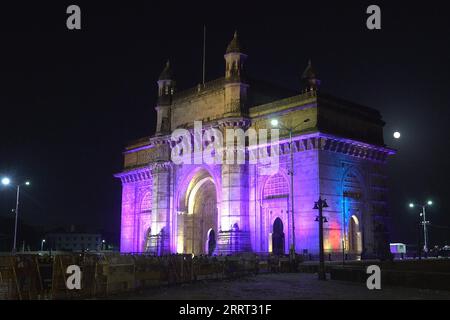 Luci colorate illuminano il Gateway of India, un monumento ad arco eretto nel 1911 per commemorare lo sbarco di re Giorgio V, il primo monarca britannico a visitare l'India a Mumbai Foto Stock