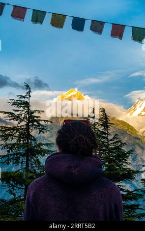 30 agosto 2023, Himachal Pradesh, India. L'uomo dai capelli lunghi guarda le montagne alpine nella Valle di Kalpa, Himachal Pradesh, che incarna un tema di vita Foto Stock