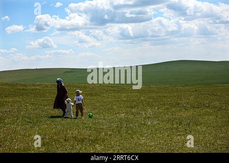 230702 -- HULUN BUIR, 2 luglio 2023 -- People Walk on the Grassland in Hulun Buir, regione autonoma della Mongolia interna della Cina settentrionale, 1 luglio 2023. CHINA-INNER MONGOLIA-HULUN BUIR-VIEW CN LANXHONGGUANG PUBLICATIONXNOTXINXCHN Foto Stock