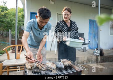 230704 -- VIENTIANE, 4 luglio 2023 -- Nouphet Thongsakda L e Phavady Nalathone preparano la cena insieme dopo il lavoro nel dormitorio della centrale idroelettrica Nam Ou 1 investita dalla Power Construction Corporation of China PowerChina a Luang Prabang, Laos, il 16 giugno 2023. Trovare un partner di vita mentre insegue i sogni di carriera non è facile, ma una giovane coppia nel nord del Laos fortunatamente ha ottenuto entrambi quando lavora per la PowerChina. ANDARE CON la caratteristica: Giovani coppie tessono sogni, amore al progetto Belt and Road in Laos foto di /Xinhua LAOS-LUANG PRABANG-BRI-POWERCHINA-GIOVANE COPPIA KaikeoxSaiyasane PUBLICATIO Foto Stock