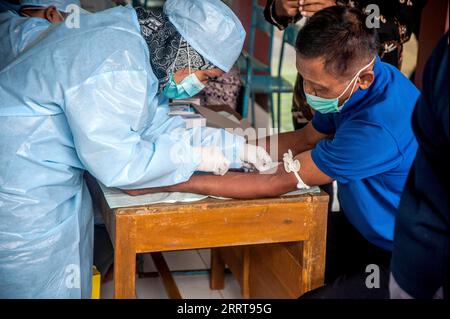 230707 -- YOGYAKARTA, 7 luglio 2023 -- Un operatore sanitario preleva un campione di sangue da un uomo per il test al villaggio di Candirejo nel distretto di Gunung Kidul, Yogyakarta, Indonesia, il 7 luglio 2023. Una persona è stata confermata morta di antrace e altri 85 hanno trovato di essere infettati dopo che tutti hanno consumato carne infetta in Indonesia provincia di Yogyakarta, ha detto autorità locali martedì. Foto di /Xinhua INDONESIA-YOGYAKARTA-ANTHRAX AgungxSupriyanto PUBLICATIONxNOTxINxCHN Foto Stock